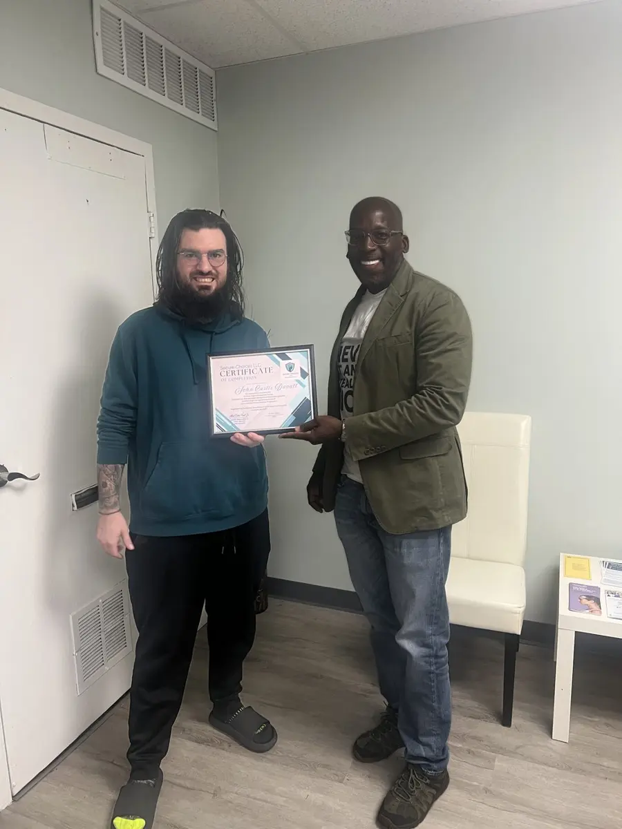 Another Secure Choices graduate receiving his certificate of completion from Albert Delon Reed Jr.